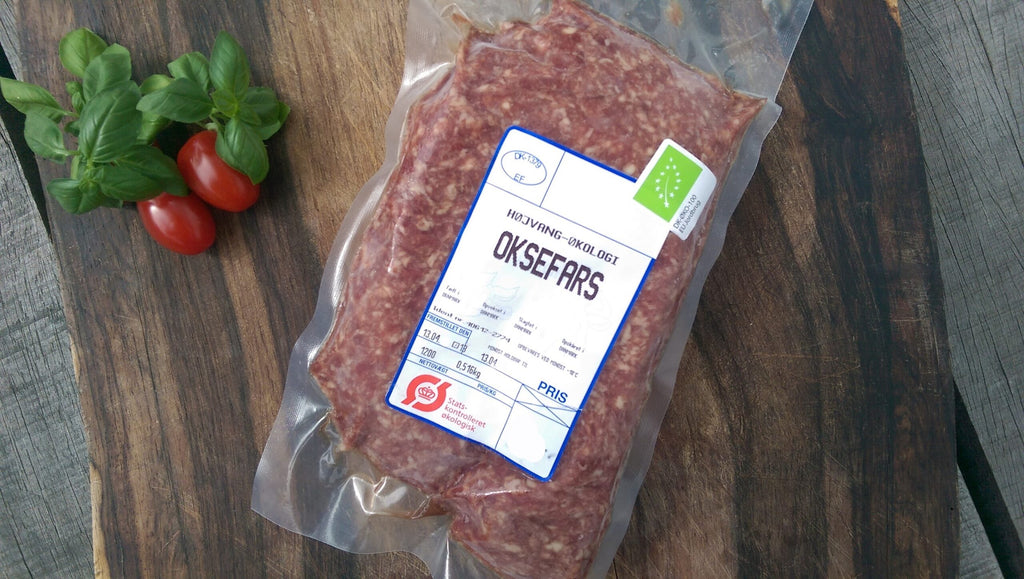 Vakuumpakket oksefars med tomater og krydderurter på et træbræt